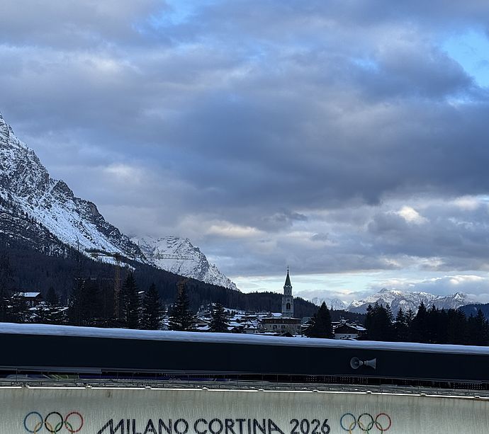 View of Olympic alpine downhill course in Cortina with spectators and mountain panorama