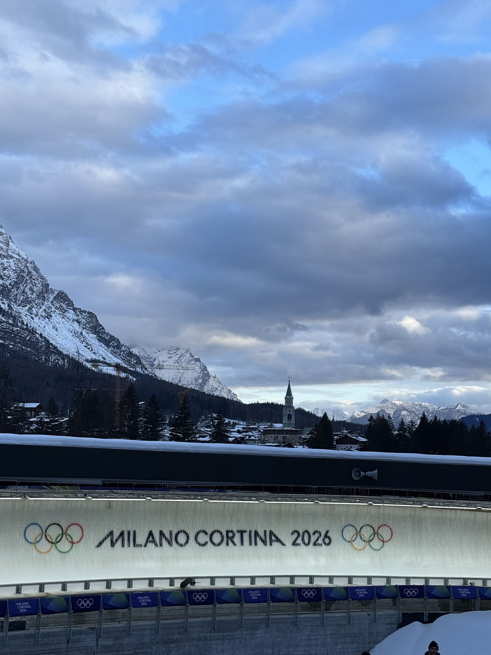 View of Olympic alpine downhill course in Cortina with spectators and mountain panorama