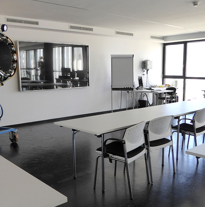 Sala formazione con tavoli, sedie e cannone da neve a elica come modello dimostrativo