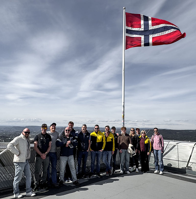 Gruppenfoto des TechnoAlpin-Teams unter wehender norwegischer Flagge auf Aussichtsplattform