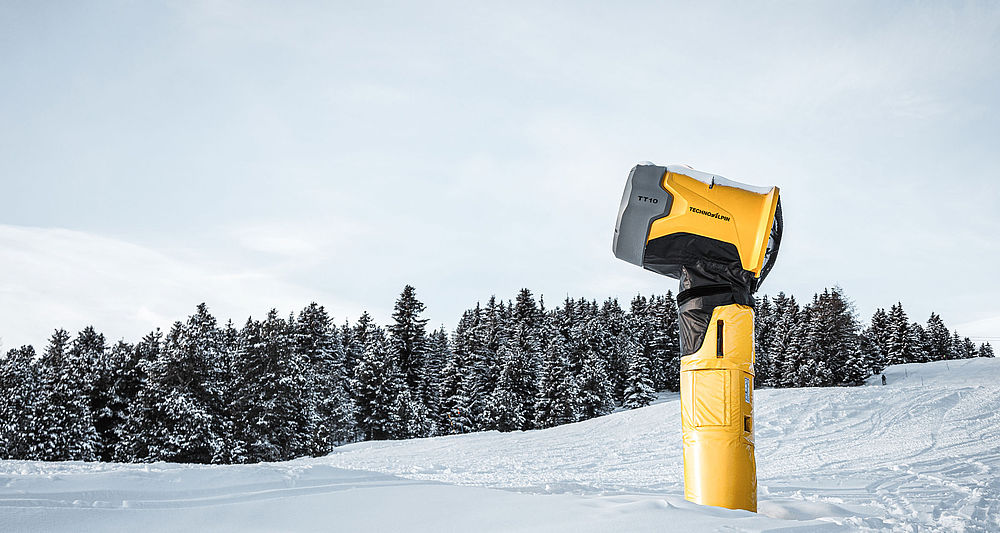 TechnoAlpin TT10 Schneeerzeuger auf verschneiter Piste vor Nadelwald