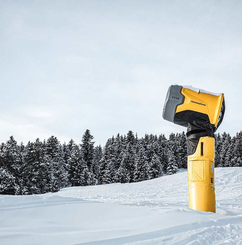 TechnoAlpin TT10 Schneeerzeuger auf verschneiter Piste vor Nadelwald