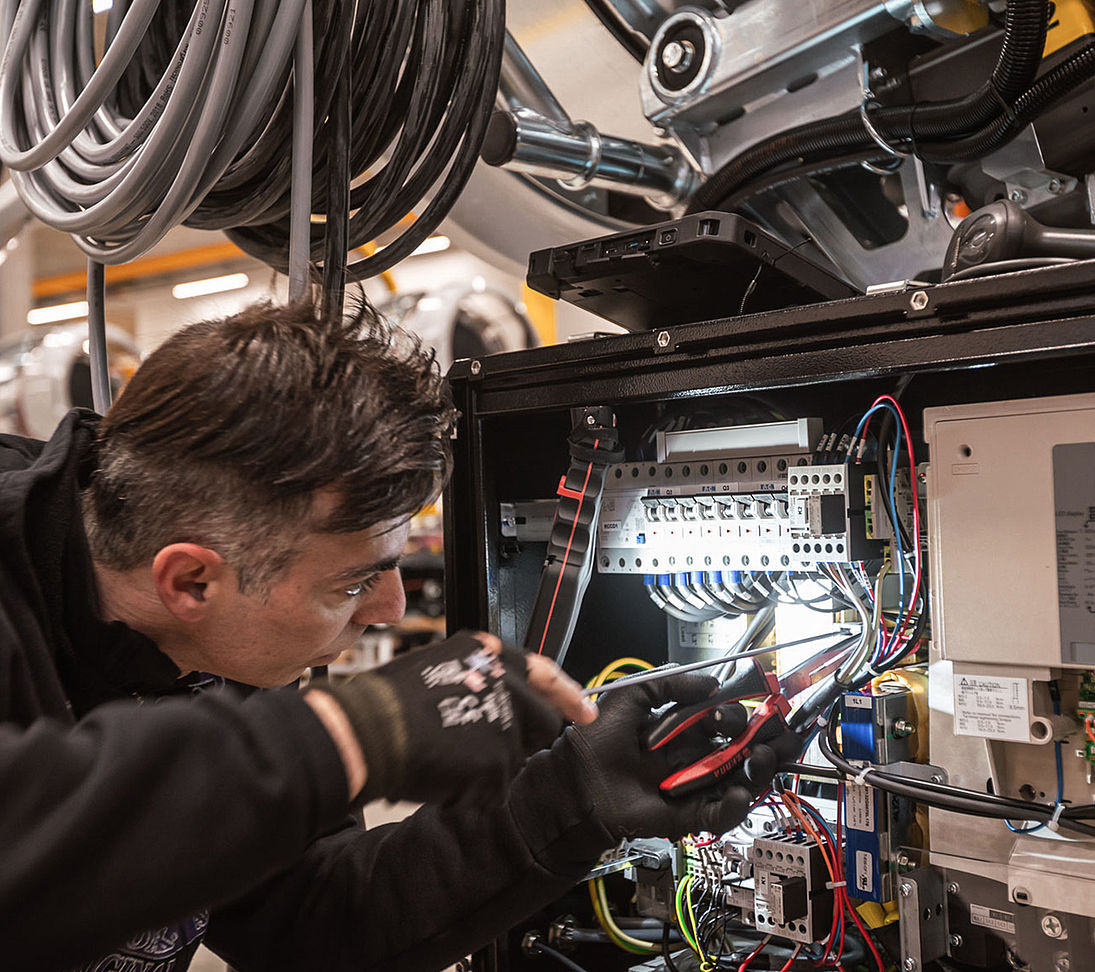 TechnoAlpin Techniker bei der Montage und Verkabelung eines Schneeerzeugers in der Produktion