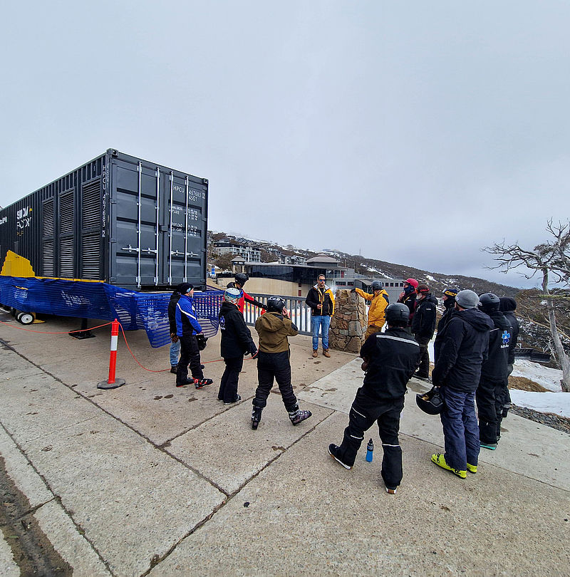 Group of people in front of SnowFactory container during training in Australia