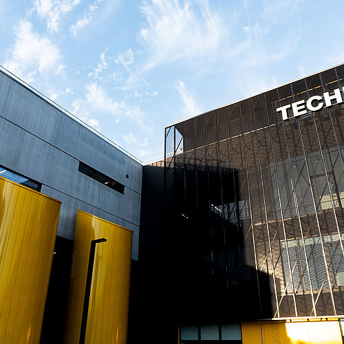 Sede TechnoAlpin in Via Siemens con accenti cilindrici gialli e logo aziendale