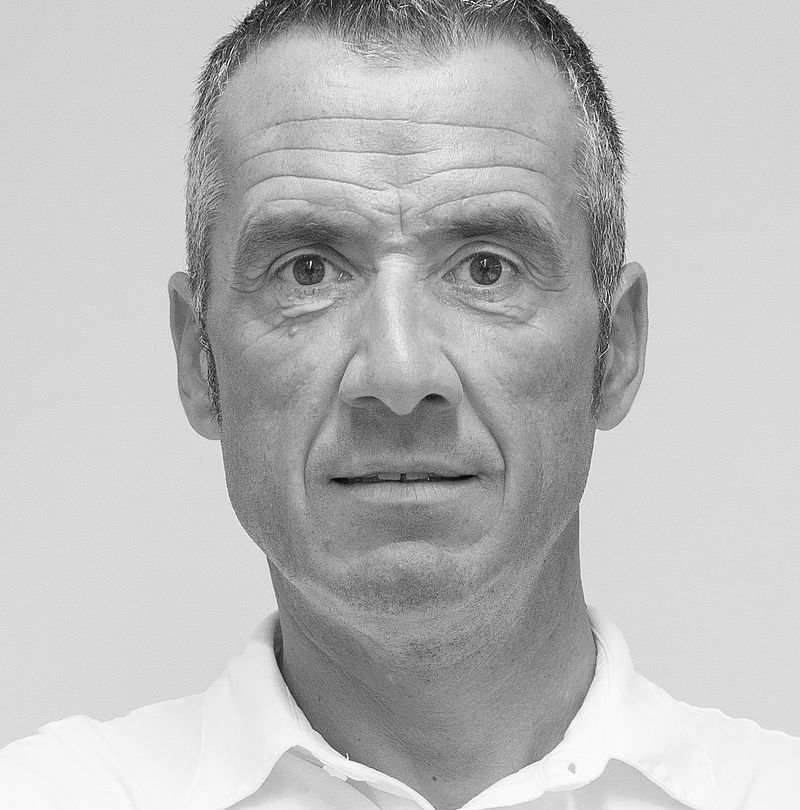 Black and white portrait of a man with grey hair and polo shirt