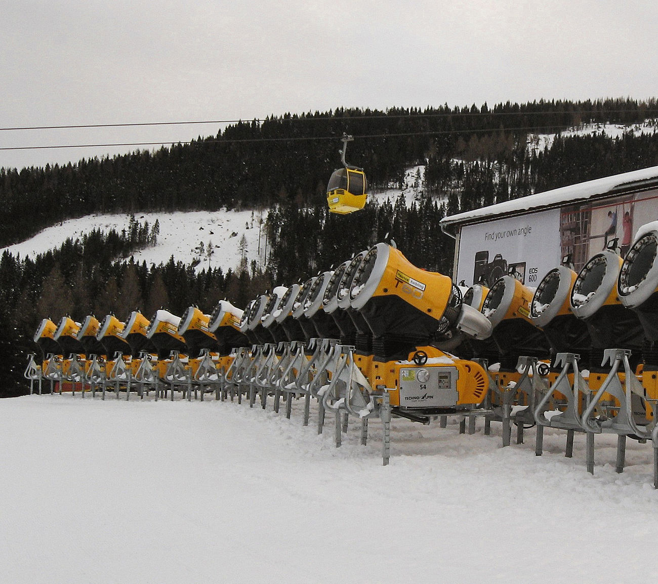 Lager mit Reihe gelber TechnoAlpin Propellermaschinen im Skigebiet