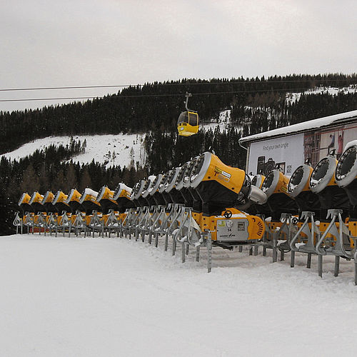 Lager mit Reihe gelber TechnoAlpin Propellermaschinen im Skigebiet