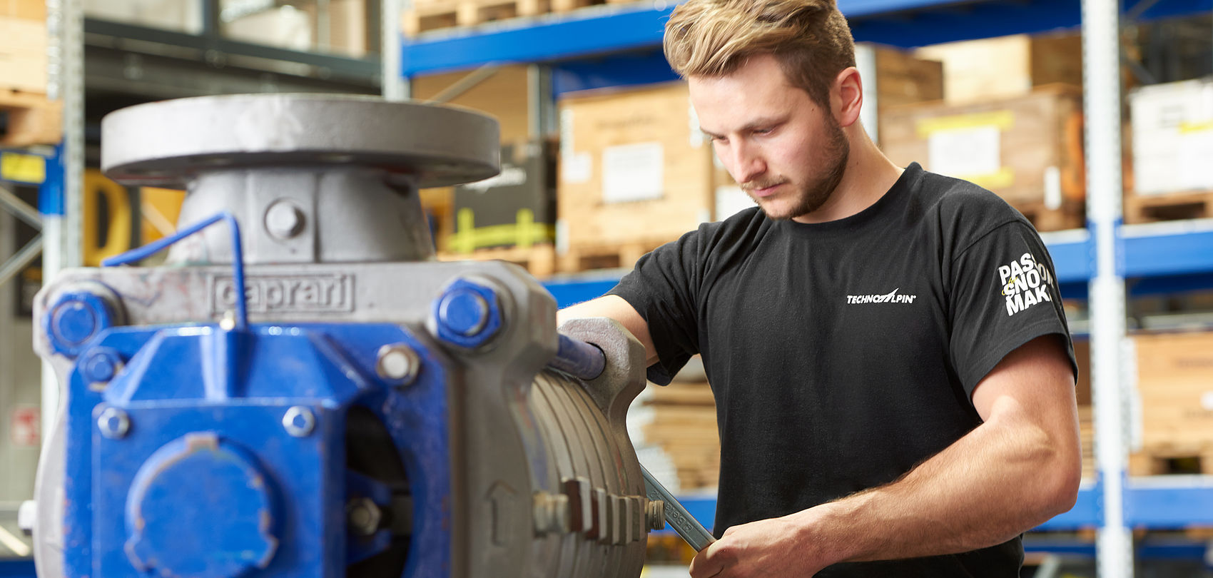 Employé TechnoAlpin effectuant la maintenance d'une pompe dans le magasin de pièces
