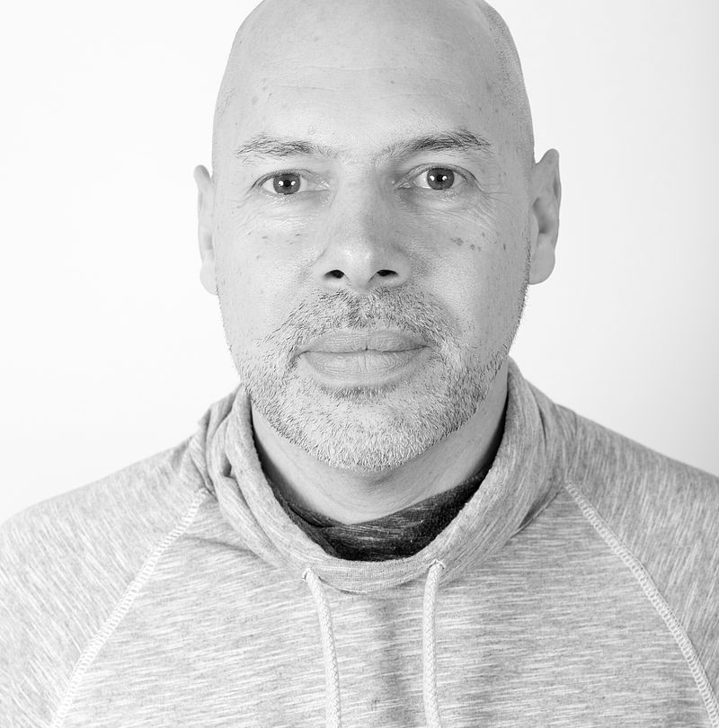 Guillaume Dugué, TechnoAlpin Mitarbeiter, Schwarz-Weiß-Portrait mit Glatze, grauem Bartansatz und neutralem Ausdruck in grauem Kapuzenpullover