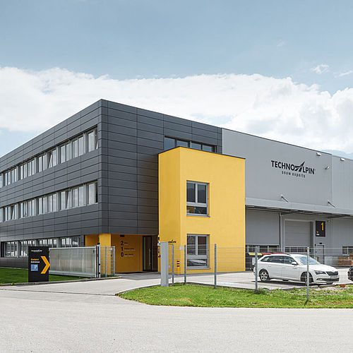 TechnoAlpin Niederlassung Österreich mit gelb-grauer Fassade und Logistikzentrum
