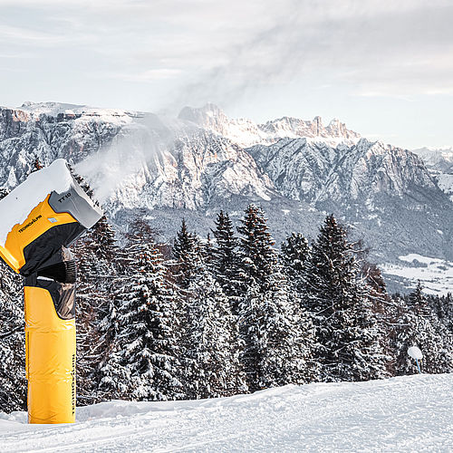 TechnoAlpin TT10 produziert Schnee mit Blick auf Dolomiten und Rosengarten