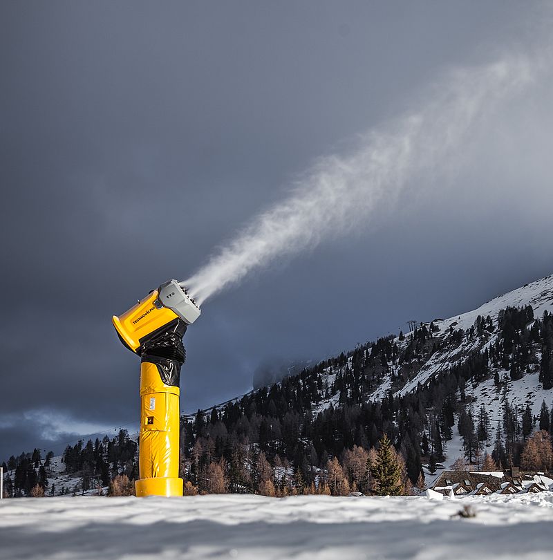 Extreme close-up of TR9 snow gun nozzle ring at Carezza spraying fine water jets for snowmaking