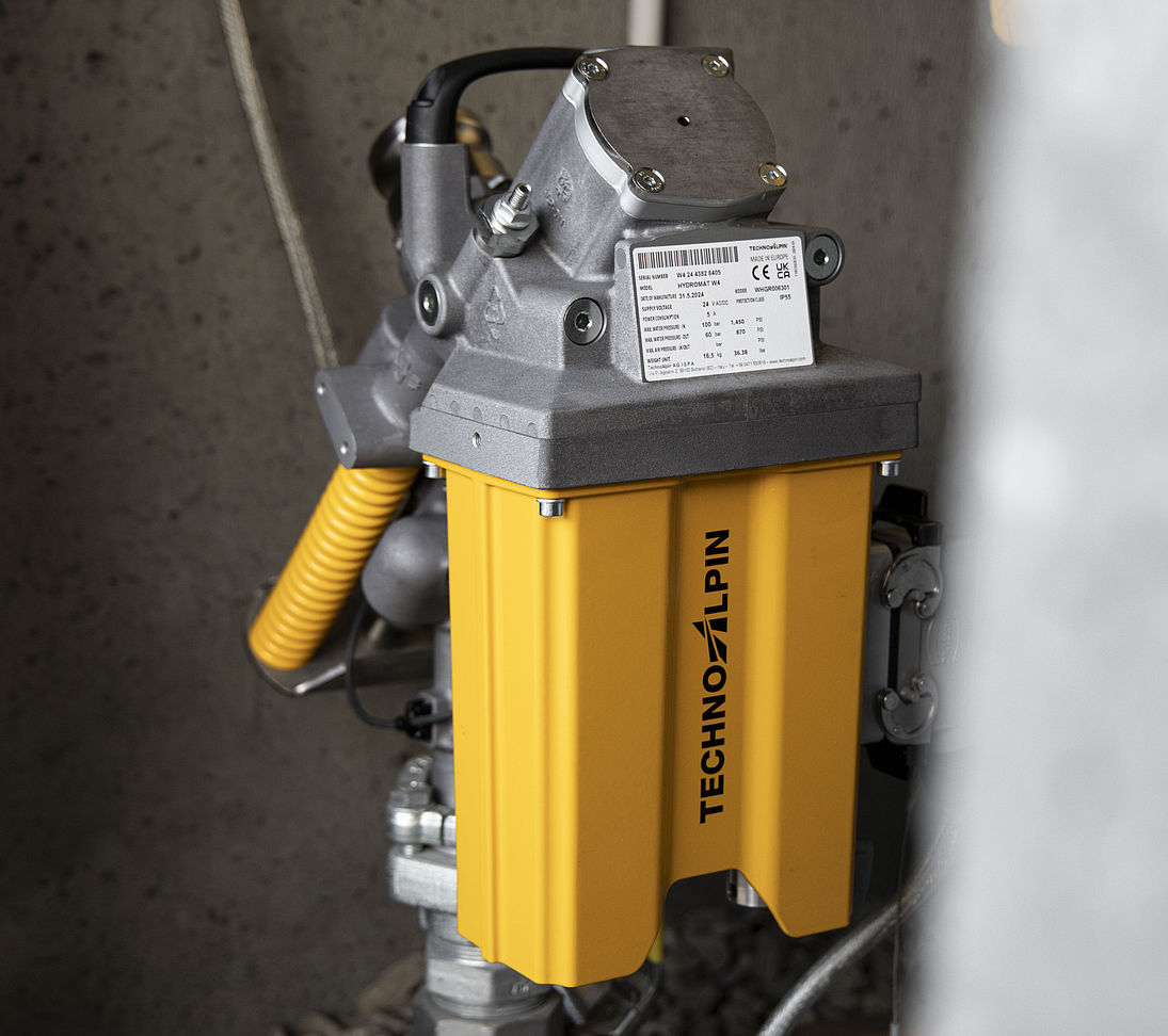 TechnoAlpin Hydromat Steuereinheit in gelb-schwarzem Gehäuse an Betonwand montiert