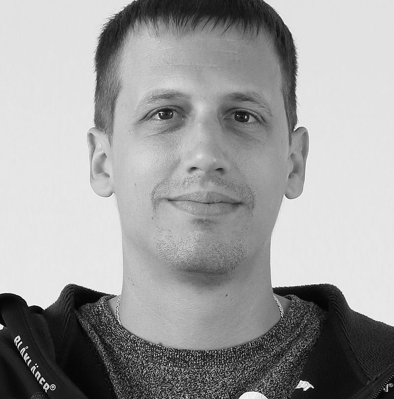 Martin Plank, TechnoAlpin Mitarbeiter, Schwarz-Weiß-Portrait mit dezentralem Lächeln, kurzem Haar und dunklem Sweatshirt