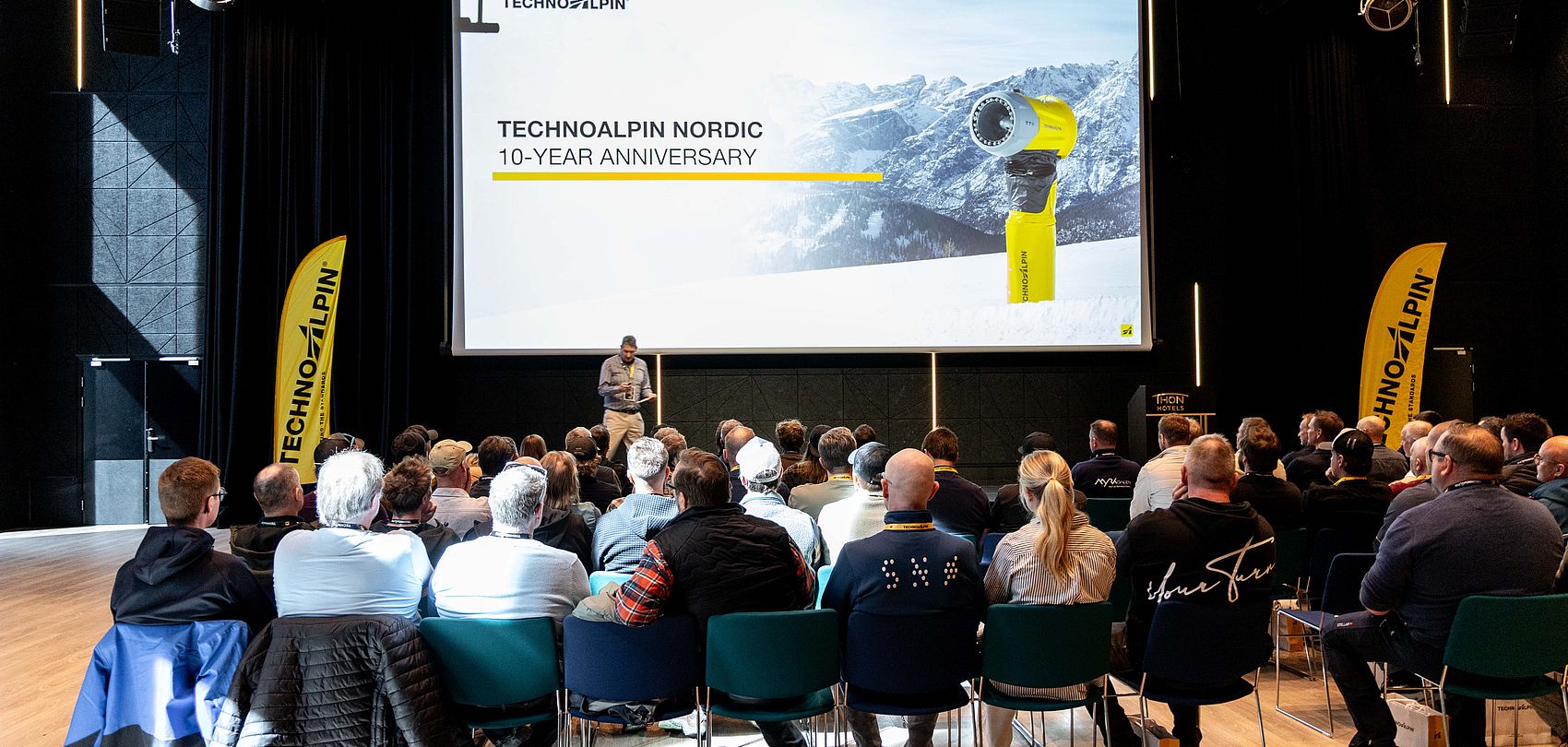 Publikum bei TechnoAlpin Nordic 10-Jahres-Jubiläumsfeier vor Präsentationsleinwand