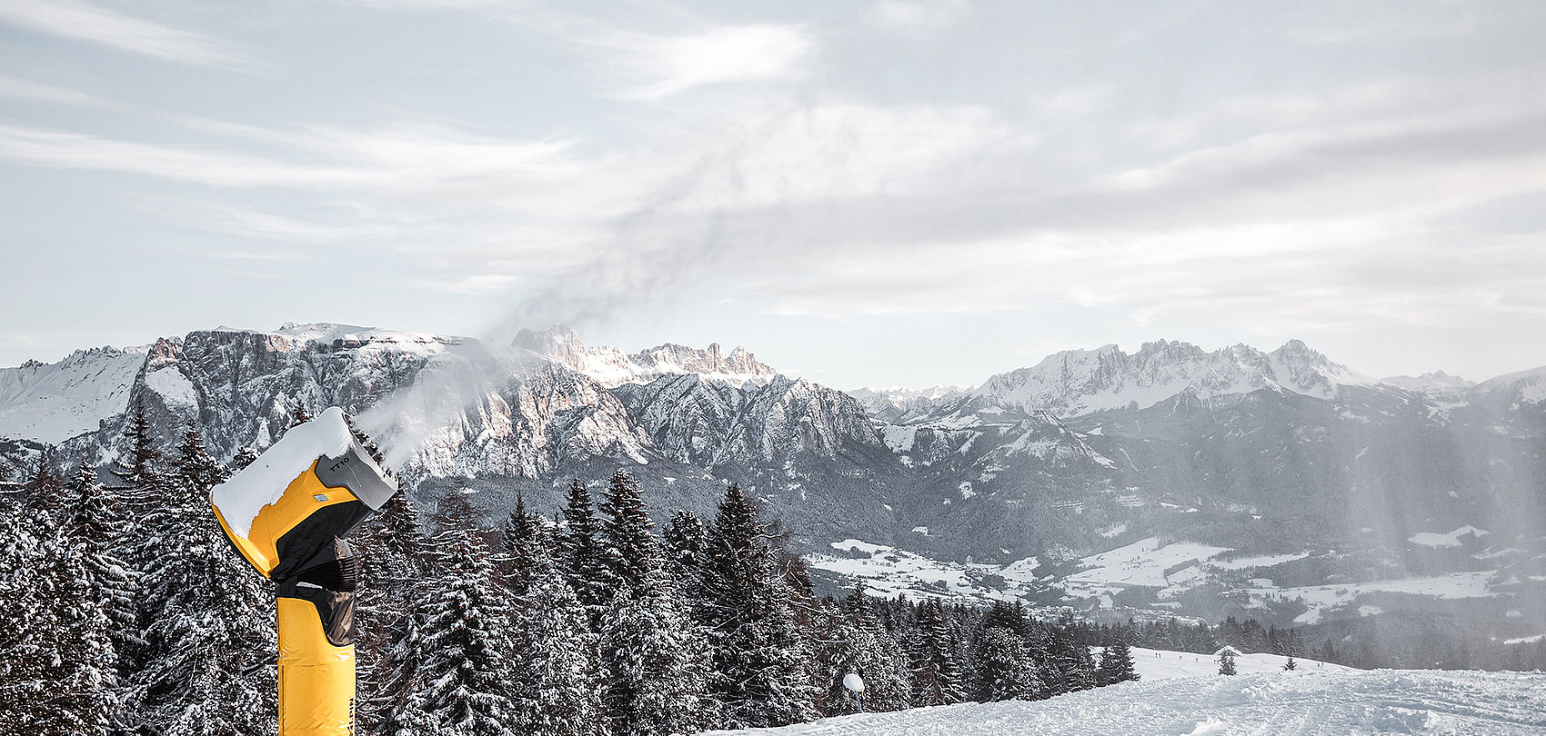 TechnoAlpin Schneeerzeuger produziert Schnee mit Blick auf die Dolomiten in Südtirol