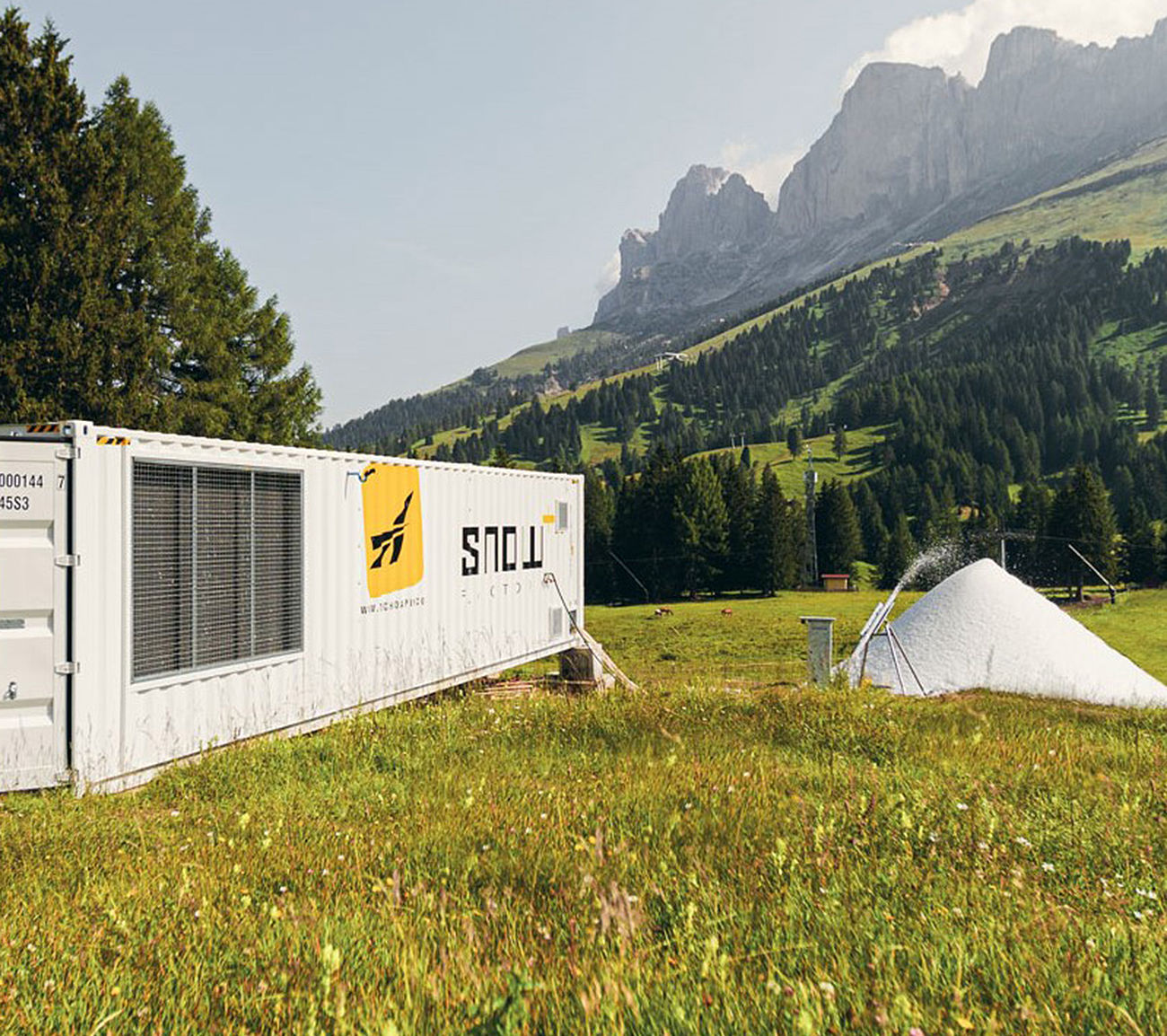 SnowFactory Container produziert Schnee auf Sommerwiese in den Dolomiten