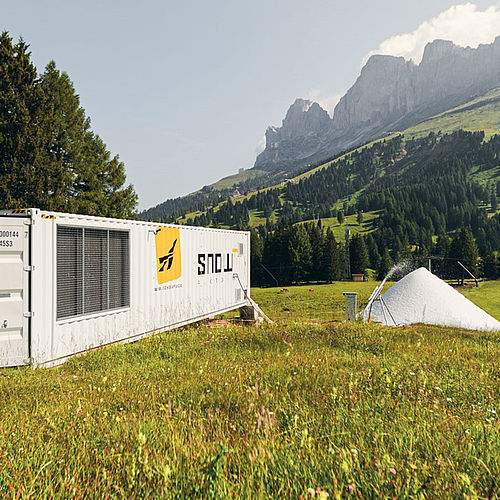 SnowFactory Container produziert Schnee auf Sommerwiese in den Dolomiten