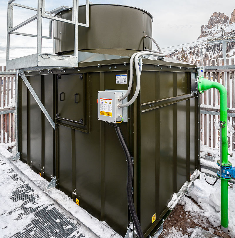Kompakter Schneeerzeuger mit grüner Wasserleitung und Wartungsplattform vor Dolomitenpanorama