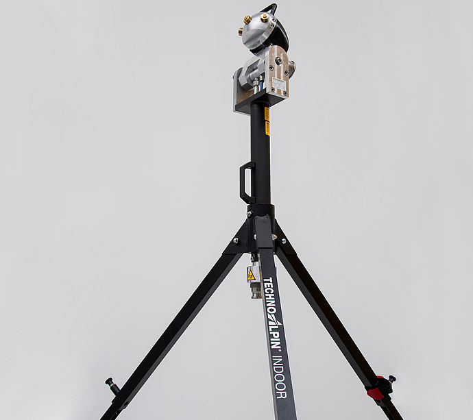 Générateur de neige TechnoAlpin Indoor sur trépied noir devant fond neutre.