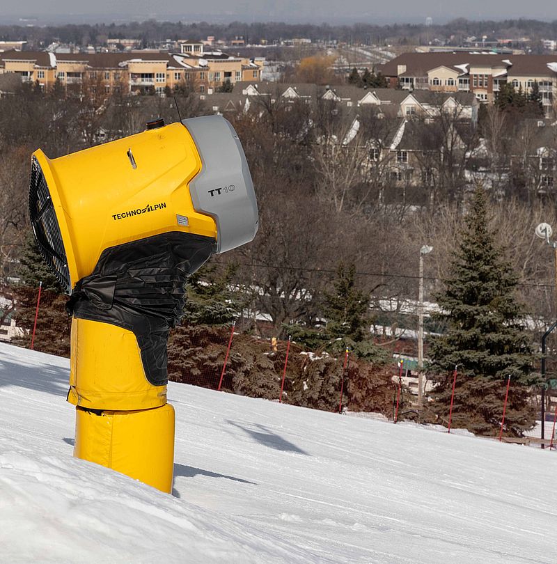 TechnoAlpin TT10 on the slope at Buck Hill ski area, with a city in the background