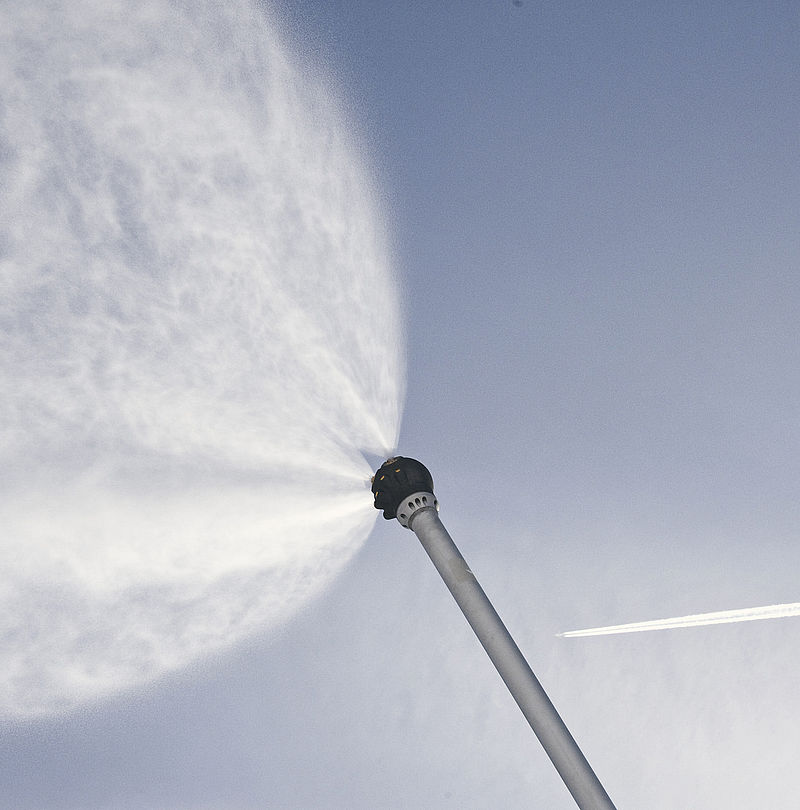 TechnoAlpin snow lance in action with fine water spray against blue sky