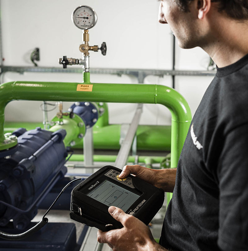Servicetechniker bedient VIBXpert Messgerät zur Schwingungsanalyse an Pumpenanlage