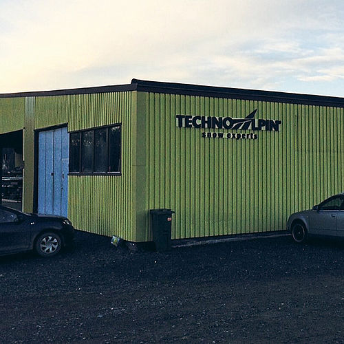 TechnoAlpin Niederlassung mit grüner Fassade und Firmenlogo