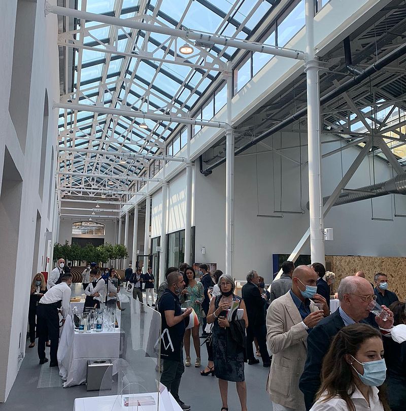 Visiteurs de l'exposition Compasso d'Oro dans hall moderne avec toit en verre