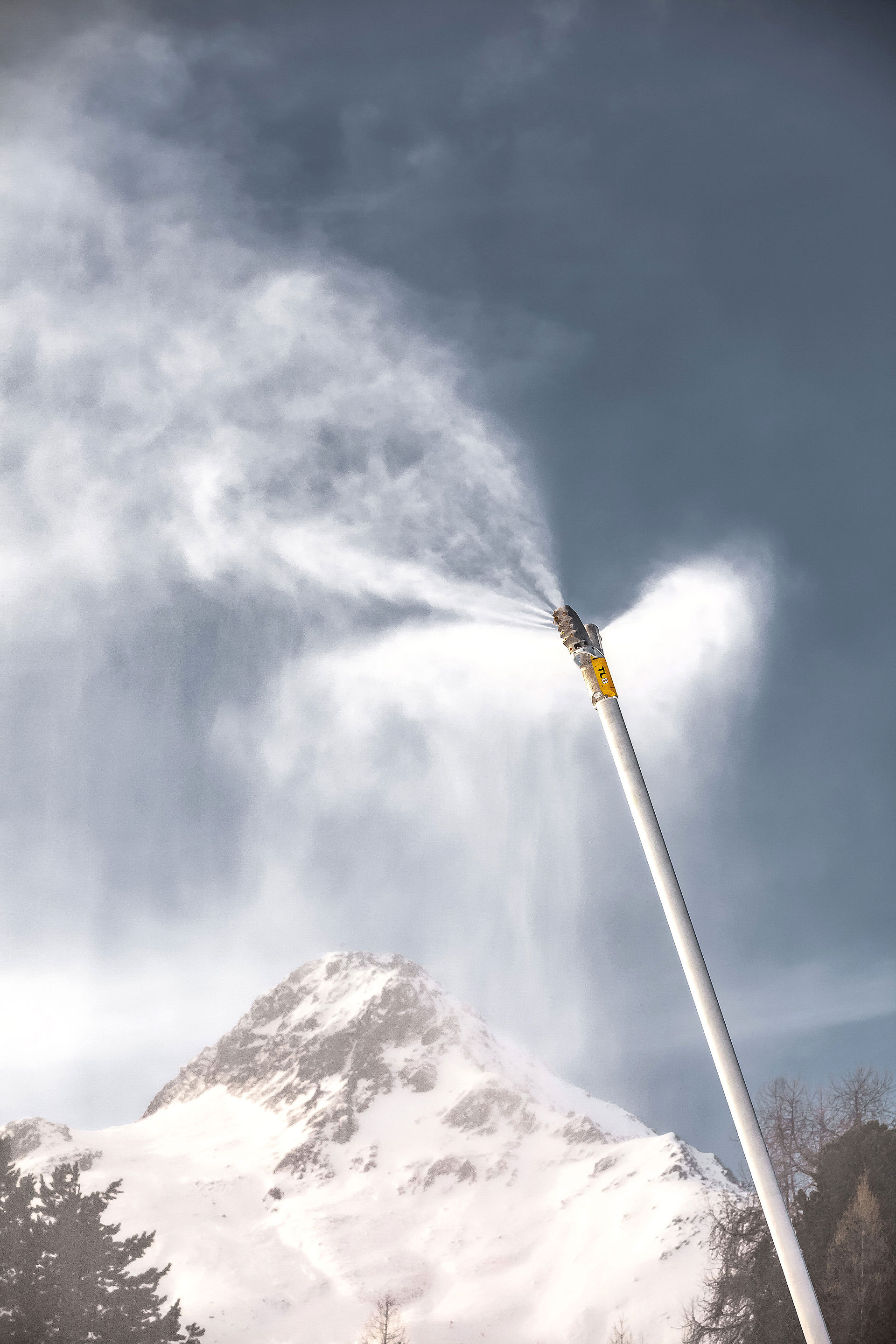 TL8 Double Schneilanze in Hochformat mit Schneenebel vor verschneitem Berggipfel