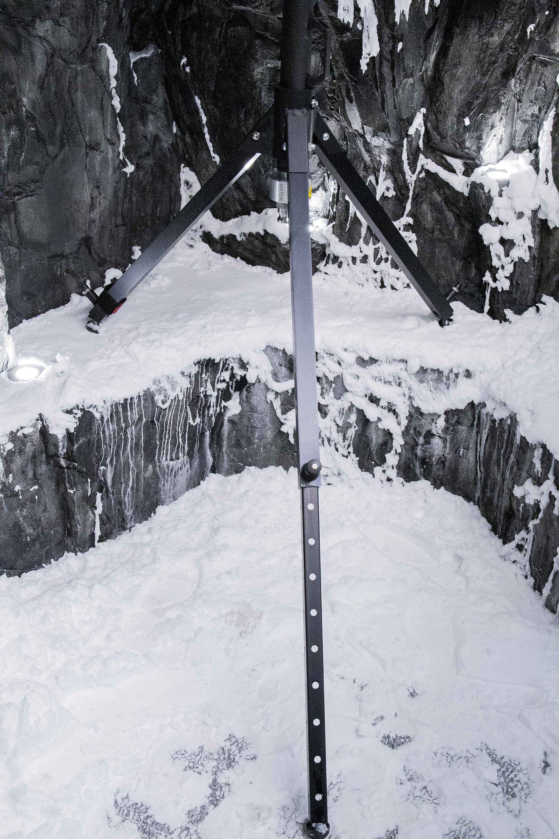 TechnoAlpin SnowRamp sur trepied sur tas de neige dans grotte rocheuse simulee en environnement de test