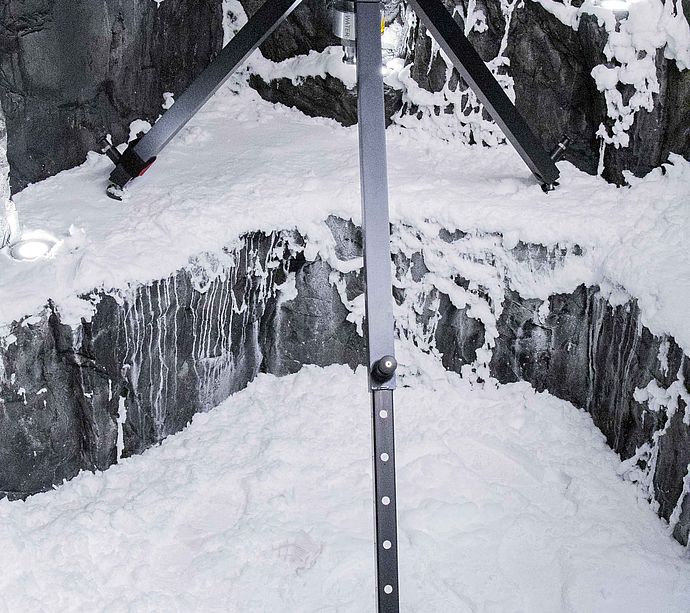 TechnoAlpin SnowRamp sur trepied sur tas de neige dans grotte rocheuse simulee en environnement de test