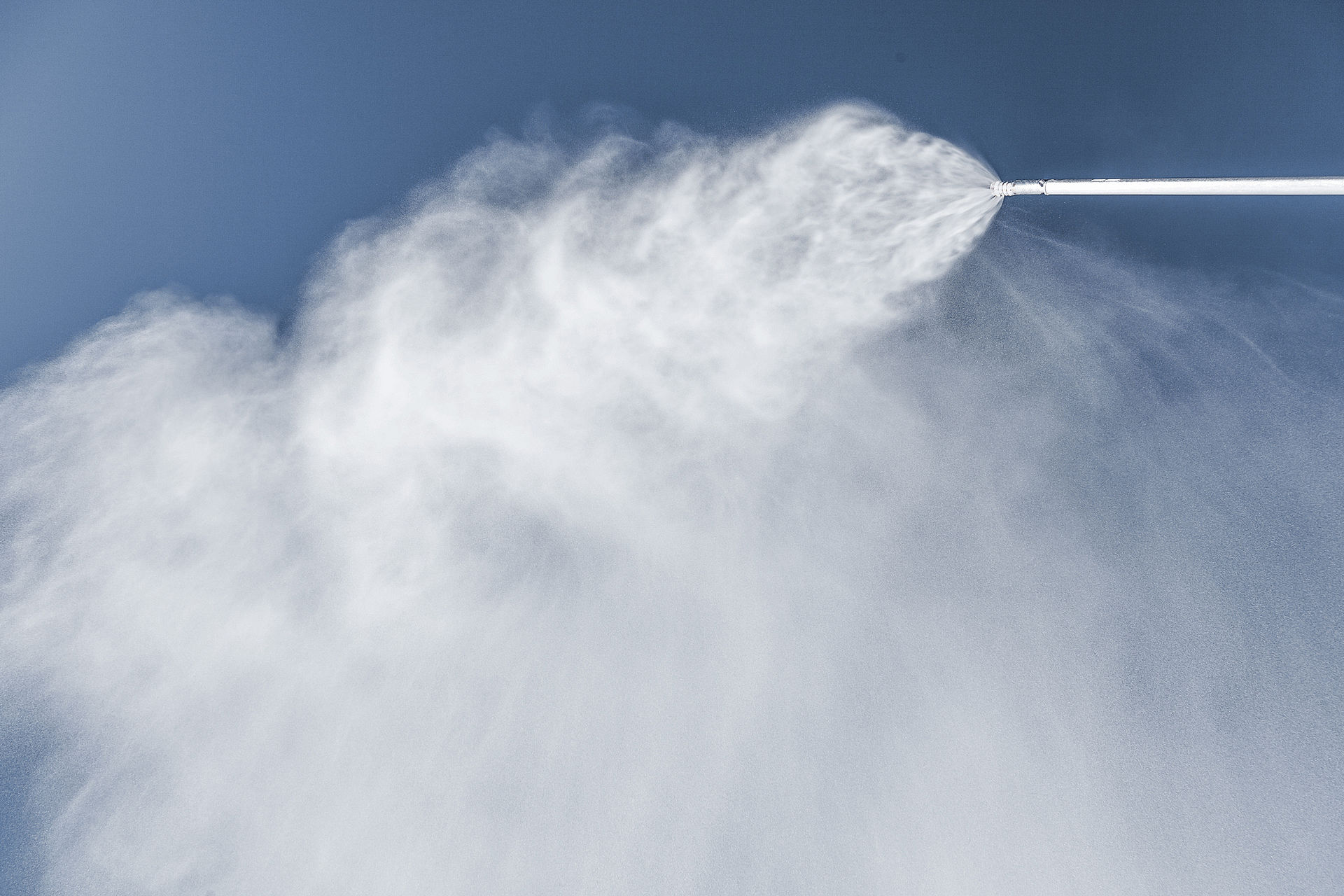 Schneestrahl einer TechnoAlpin Snowlance vor blauem Himmel beim Beschneien