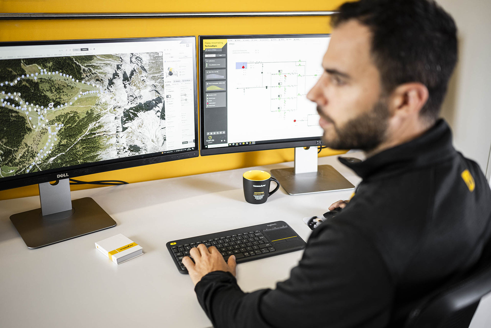 TechnoAlpin Mitarbeiter am Arbeitsplatz mit Beschneiungssoftware auf zwei Monitoren