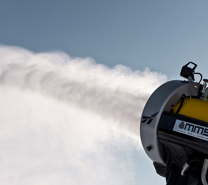 MMS Schneekanone von TechnoAlpin erzeugt kraftvollen Schneestrahl vor blauem Himmel