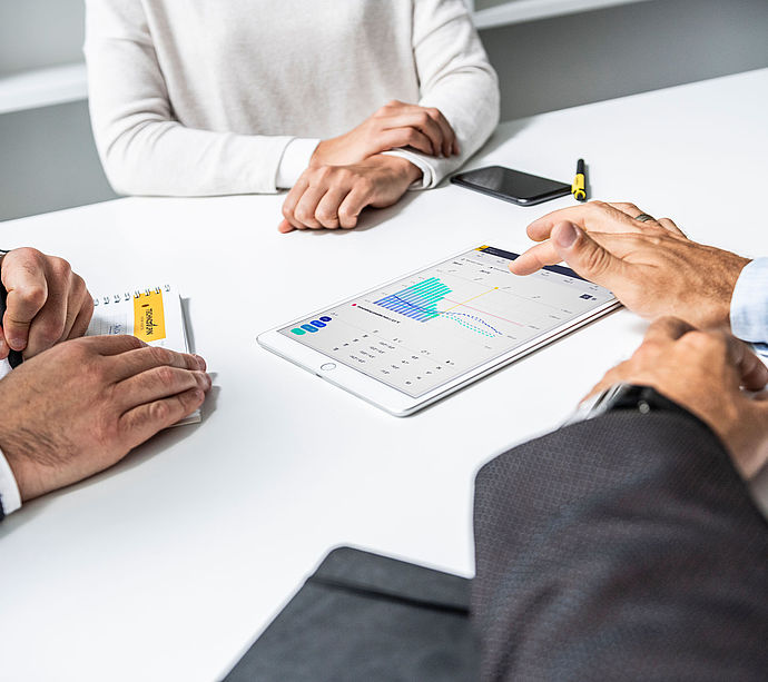 Besprechung mit Tablet zur Analyse der Beschneiungsdaten