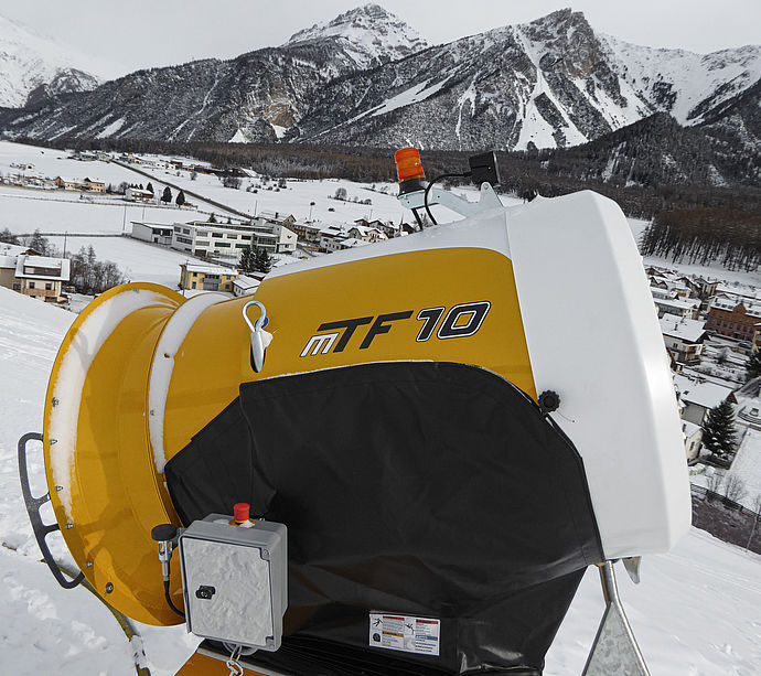 TechnoAlpin MTF 10 Propellerschneekanone mit Steuerbox auf Piste vor Alpenpanorama