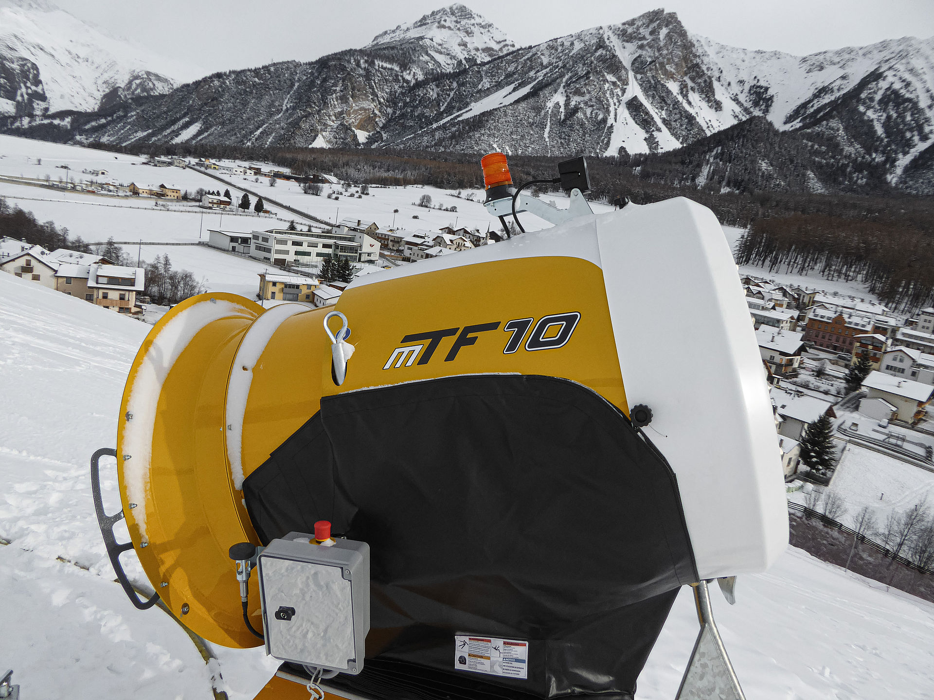 TechnoAlpin MTF 10 Propellerschneekanone mit Steuerbox auf Piste vor Alpenpanorama