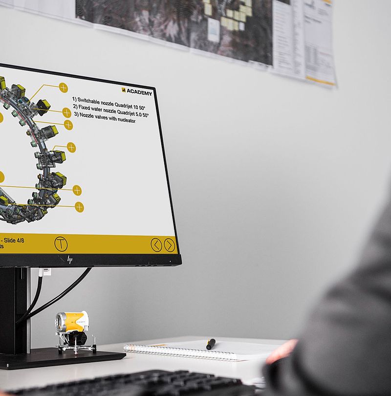 Person at desk in front of screen with Academy training content on nozzle ring components