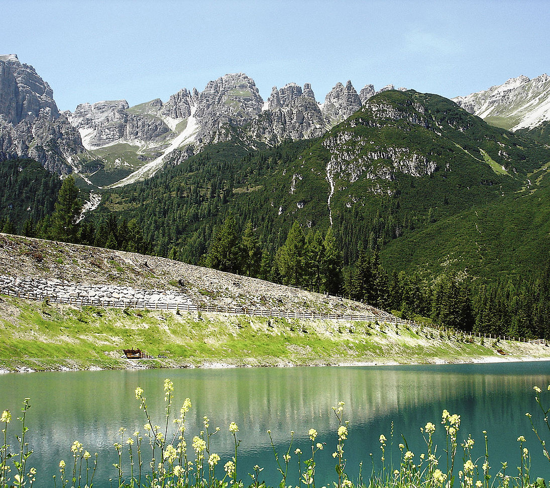 Speichersee für Beschneiung im Sommer mit Dolomitenpanorama