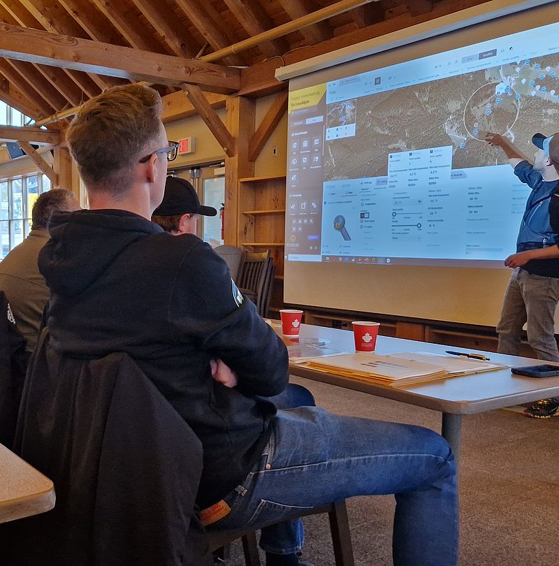 Teilnehmer betrachten Präsentation der Snowvisual Software auf Leinwand im Schulungsraum