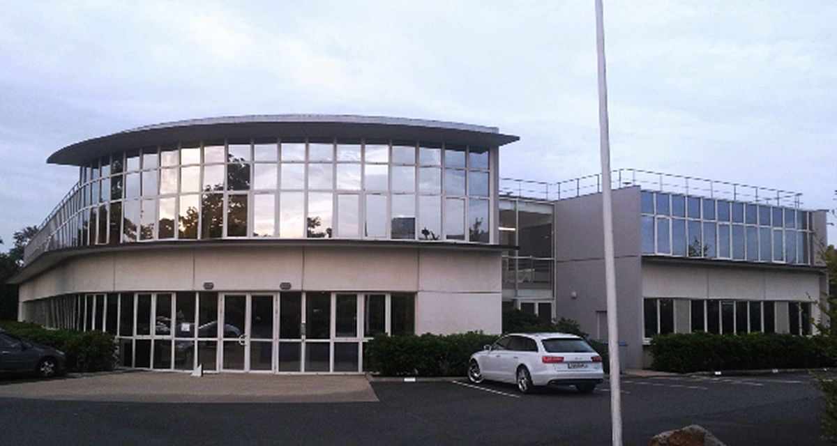TechnoAlpin Niederlassung Frankreich mit moderner runder Glasfassade und Parkplatz