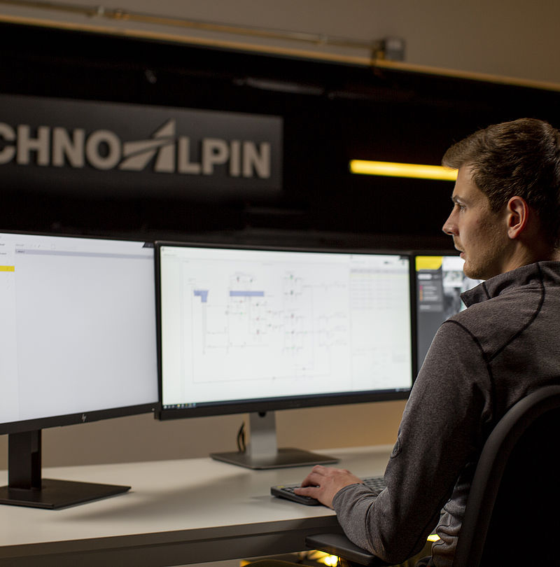 TechnoAlpin employee in control room monitoring snowmaking system on multiple screens