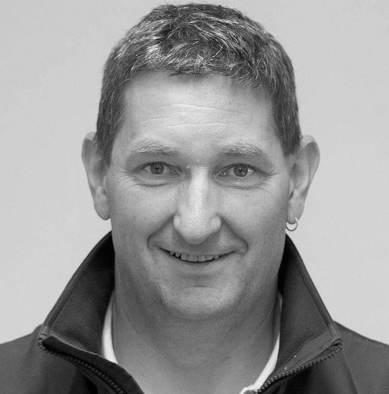 Wolfgang Hanni, TechnoAlpin Mitarbeiter, Portrait mit graumeliertem Kurzhaar, freundlichem Lächeln und kleinem Ohrring in dunkler Reißverschlussjacke
