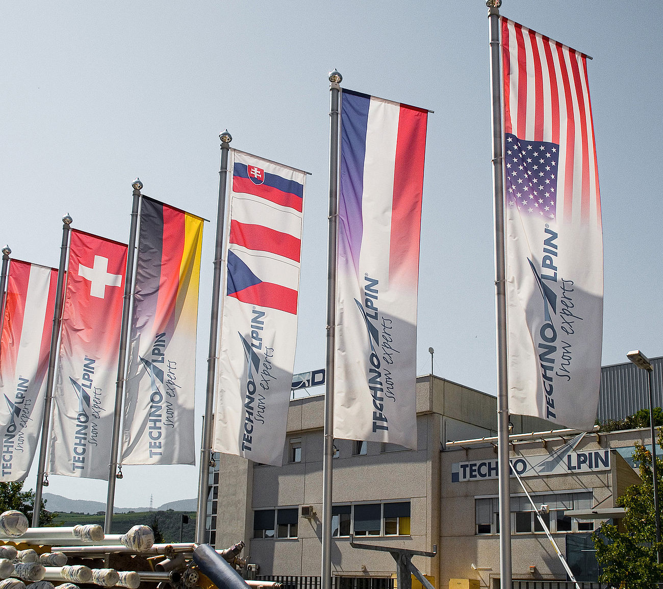 Internationale Flaggen vor TechnoAlpin Hauptsitz symbolisieren globale Präsenz
