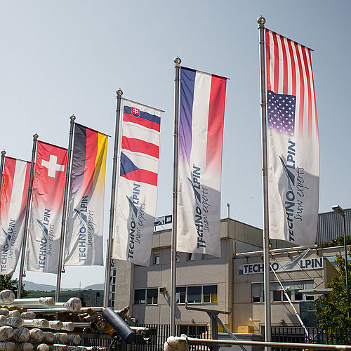 Internationale Flaggen vor TechnoAlpin Hauptsitz symbolisieren globale Präsenz