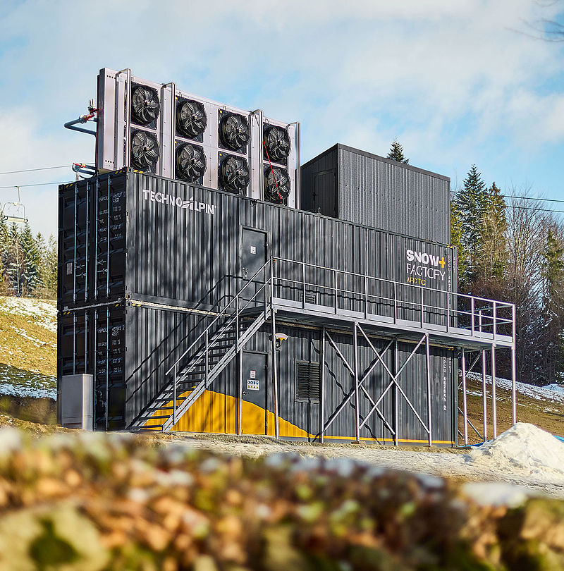 Impianto SnowFactory Arctic con ventilatori sul tetto davanti a seggiovia e bosco