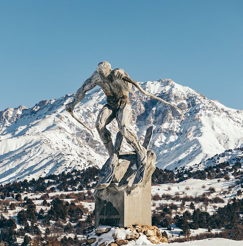 Skier statue in front of mountain panorama at Amirsoy ski resort in Uzbekistan