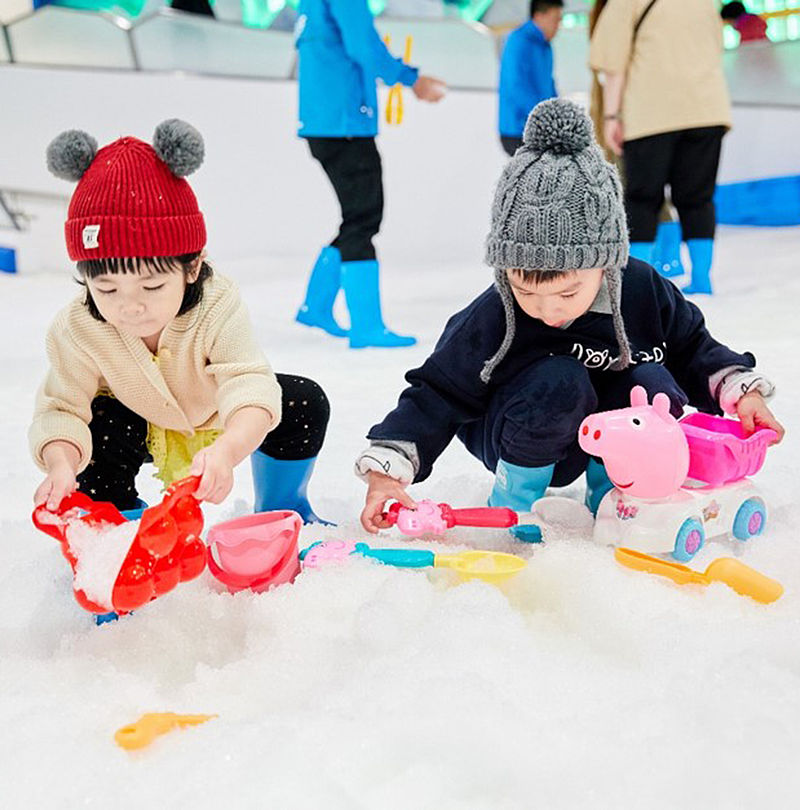 Kinder spielen mit Spielzeug im Indoor-Schnee einer SNOWROOM Anlage von TechnoAlpin